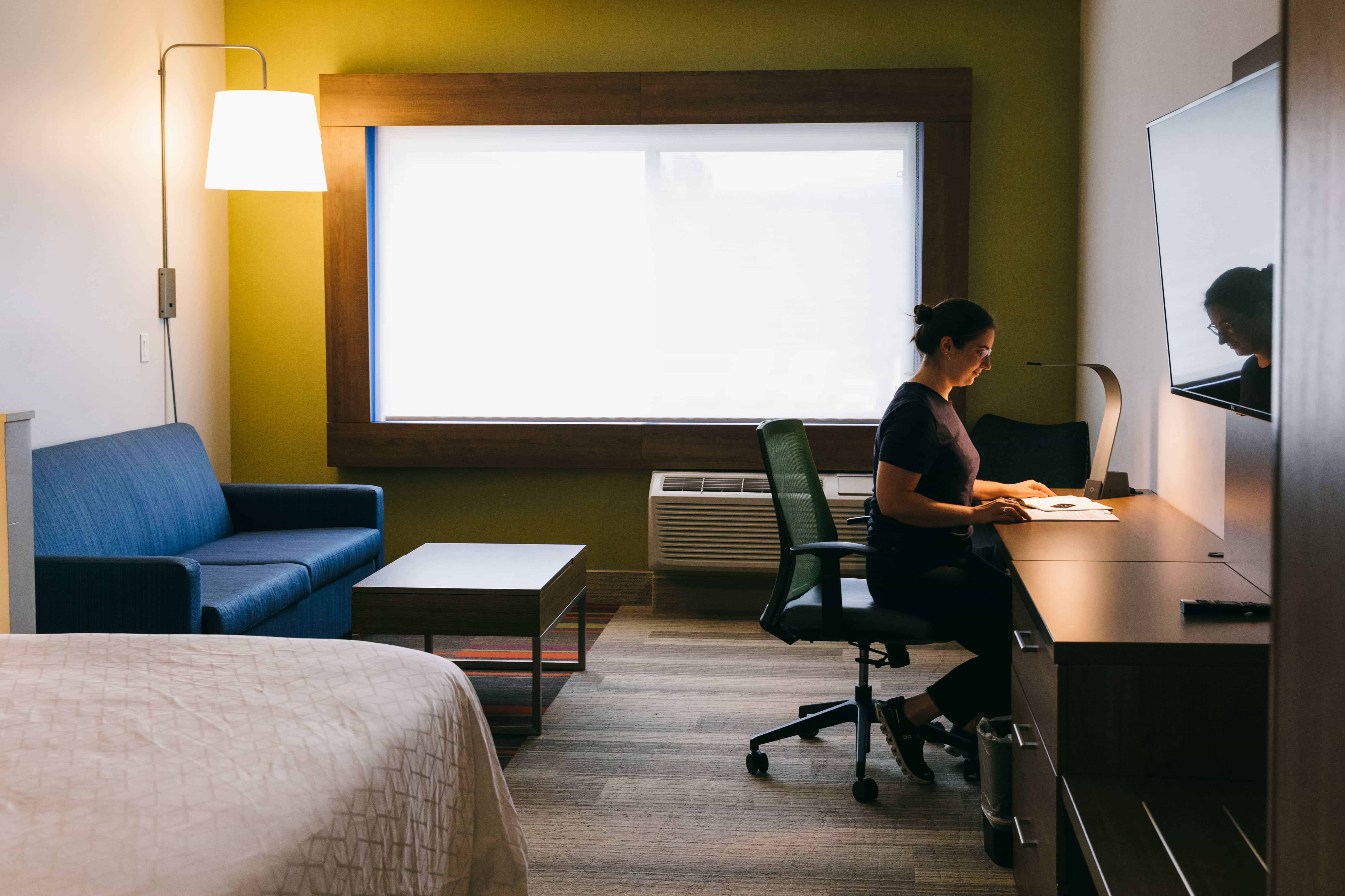 someone sitting at desk in hotel room