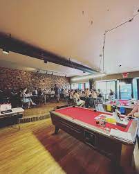 Interior of bar with people and pool tables