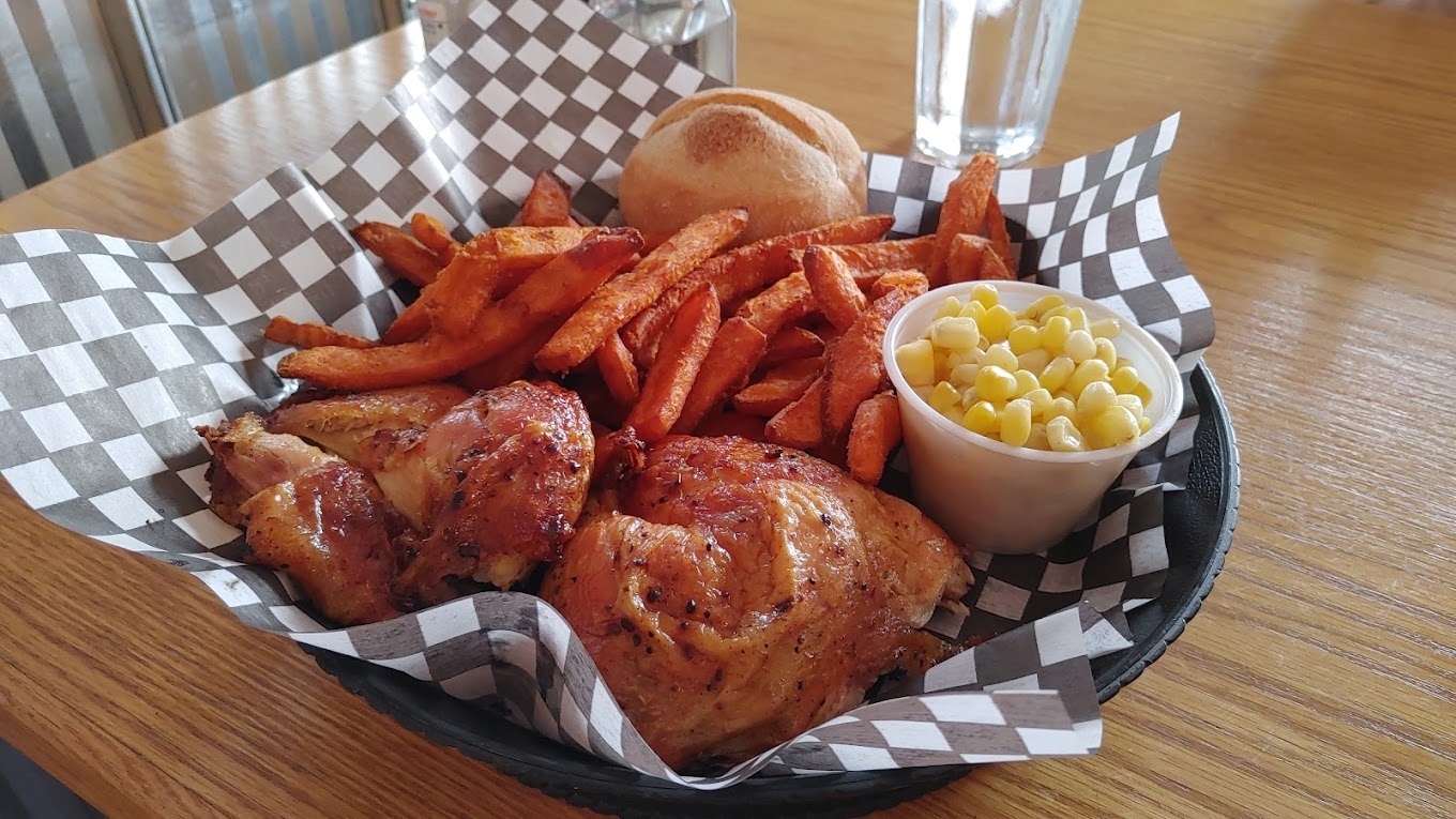 chicken, fries, and corn in a basket with checkered paper lining