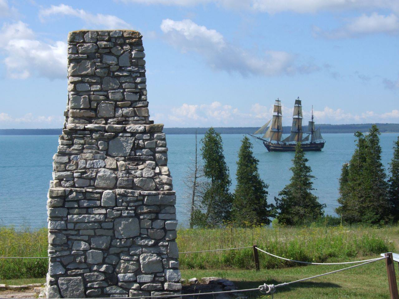 Ruins looking out over water with sail ship