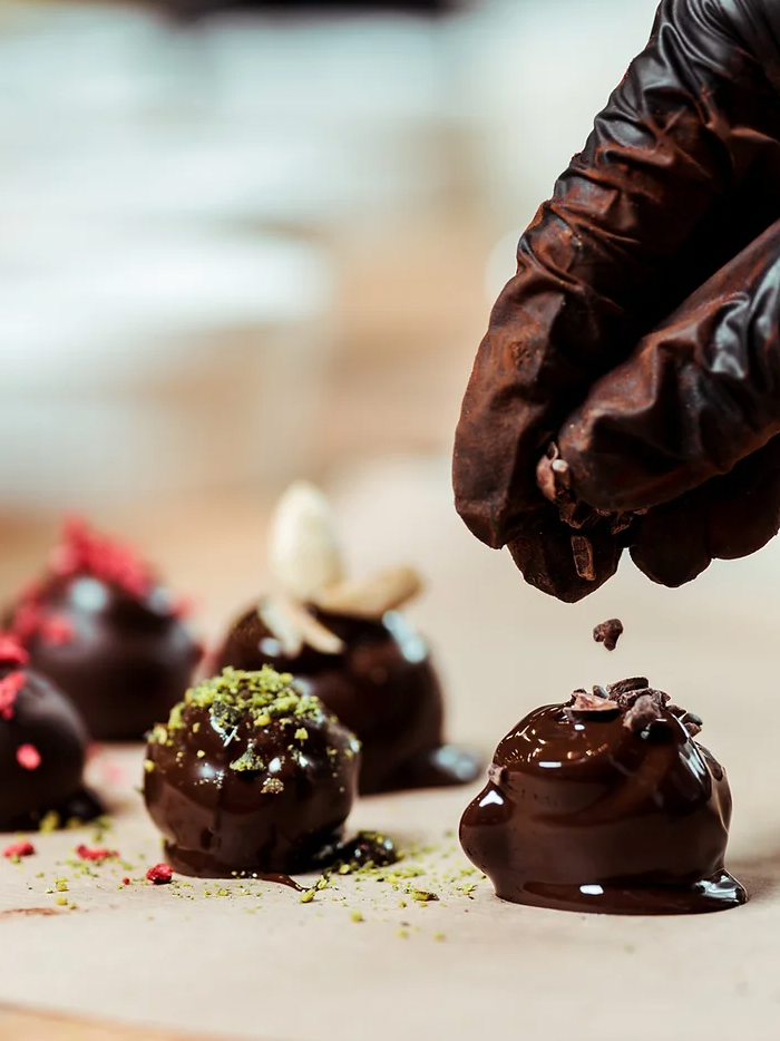 gloved hand decorating chocolates