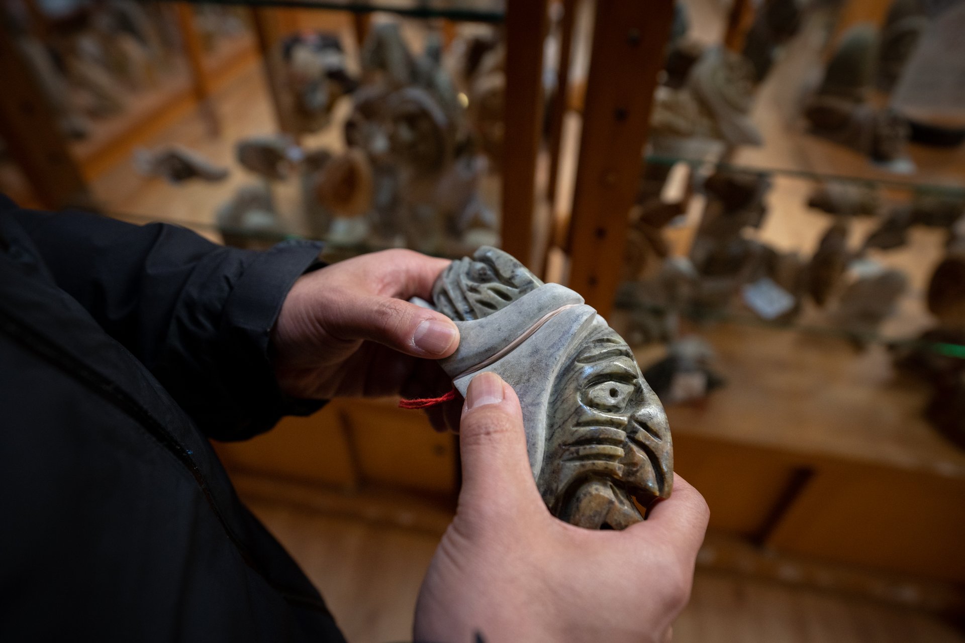 a person holding an indigenous carving