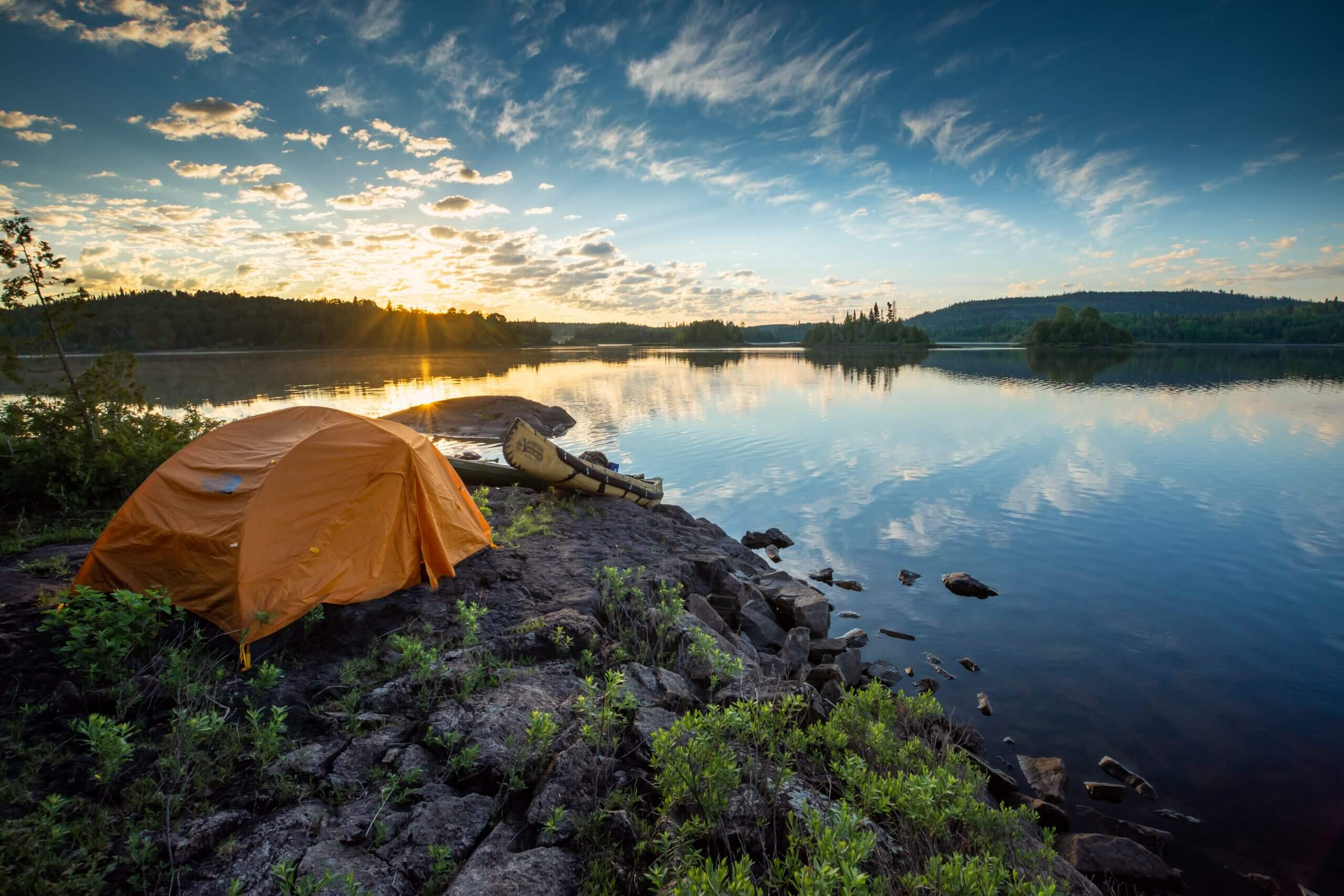 Tent and canoe on shore of lake