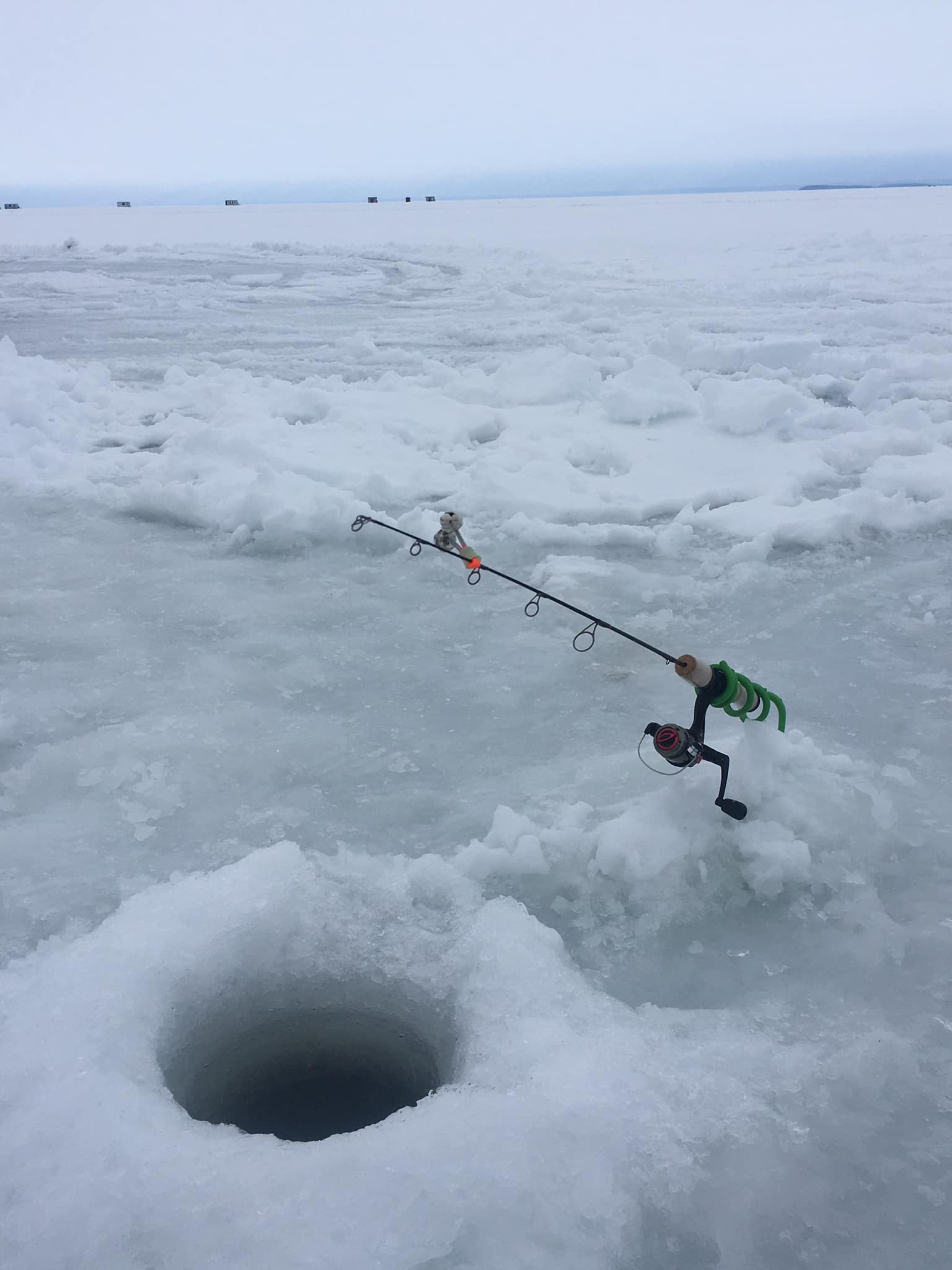 Fishing rod in hole on frozen lake