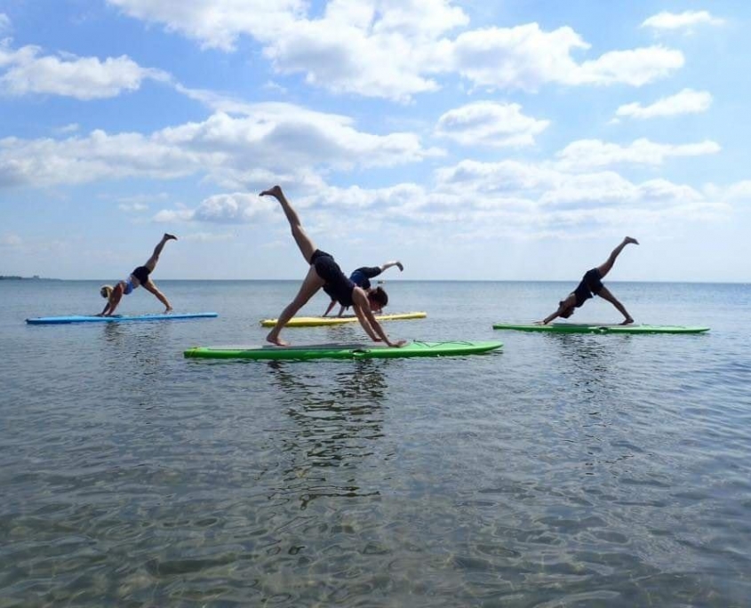 3 people doing stand up paddleboard yoga with Ontario Staycation Adventures