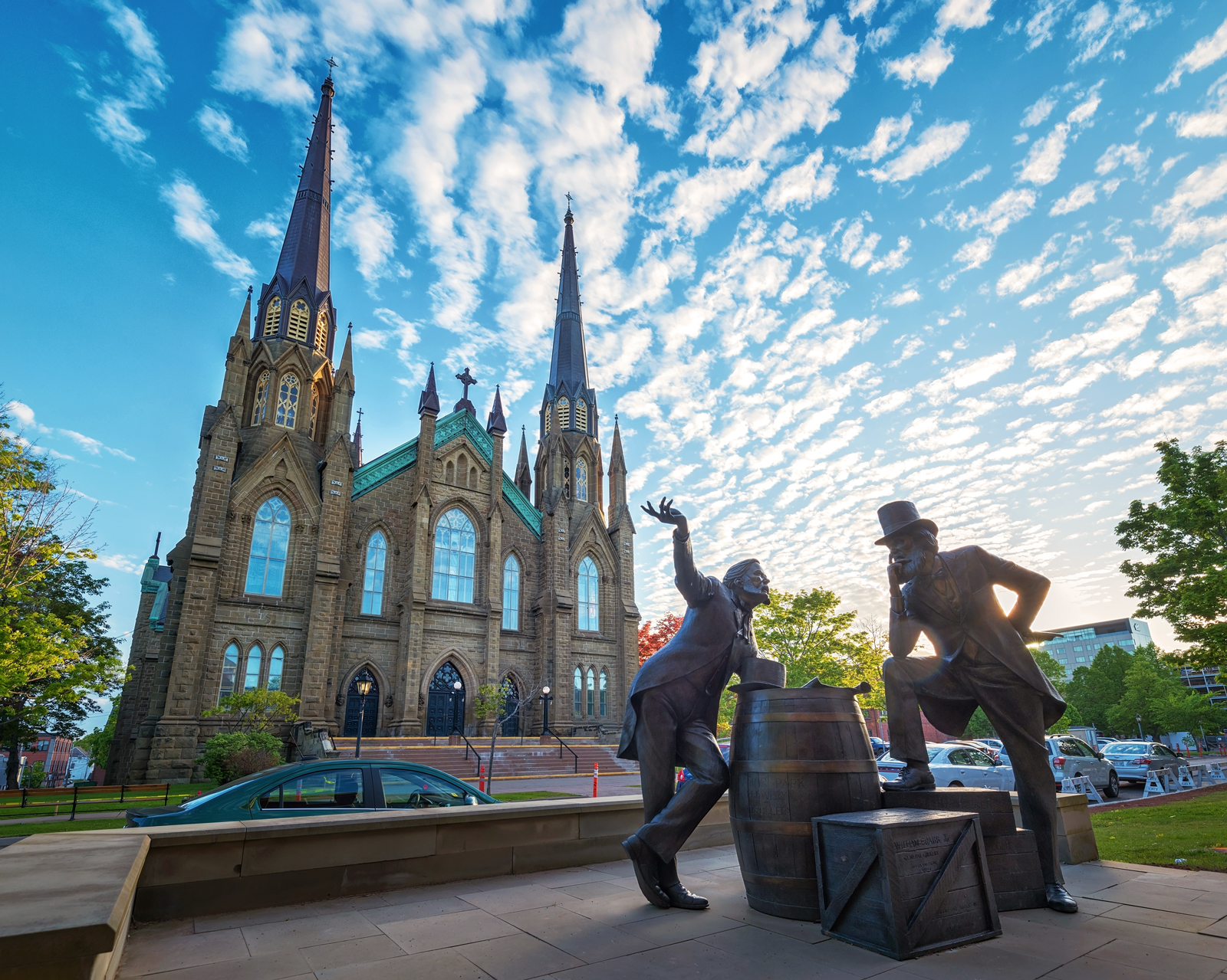 a statue with two men in front of a church