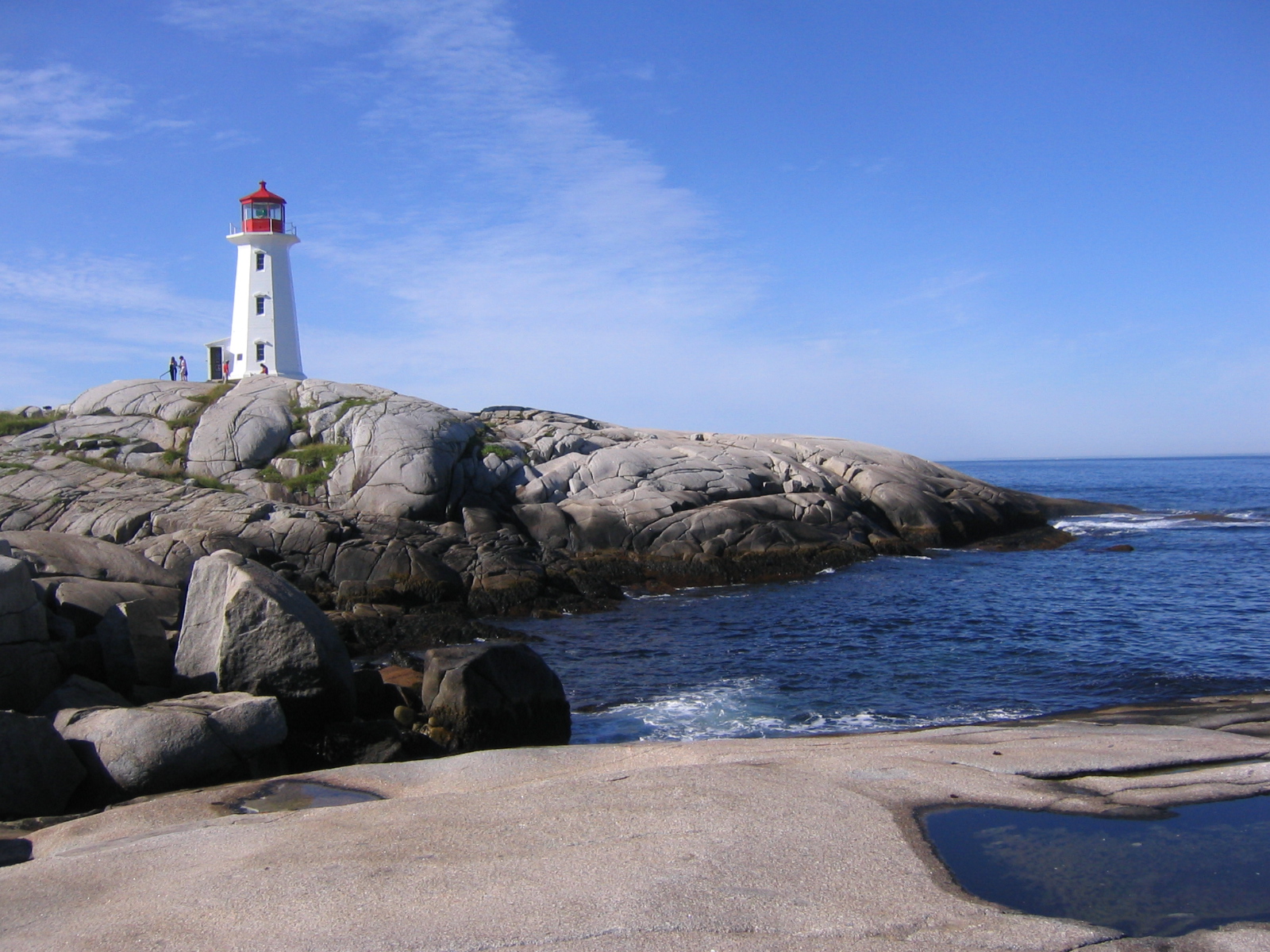 lighthouse on rocks beside a shoreline