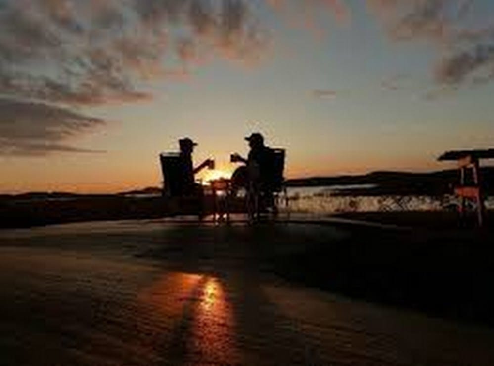 Two people enjoying the sunset.