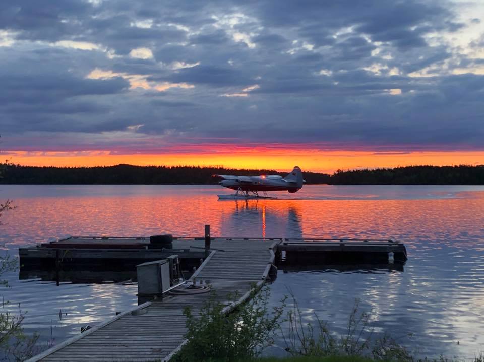 Airplane on lake at sunset