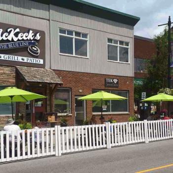 dining patio between sidewalk and building