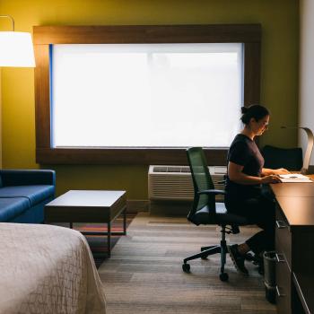 someone sitting at desk in hotel room