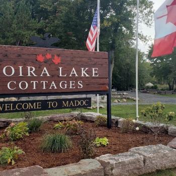 Wooden sign that states "Moira Lake Cottages"