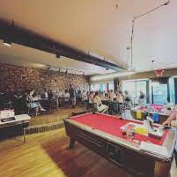 Interior of bar with people and pool tables