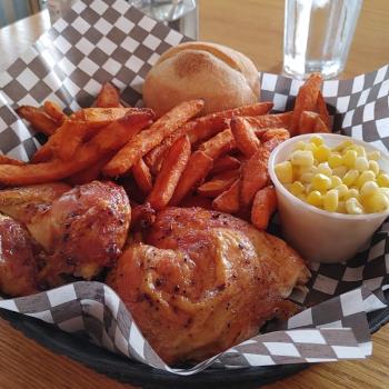 chicken, fries, and corn in a basket with checkered paper lining