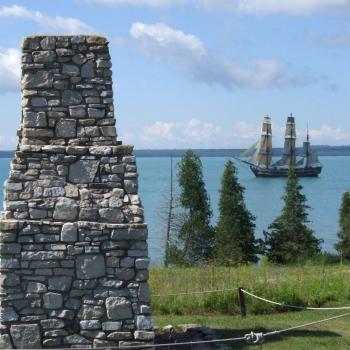 Ruins looking out over water with sail ship