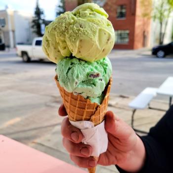 a person holding an ice cream cone with two scoops