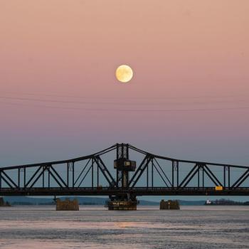 the swing bridge with the moon above it