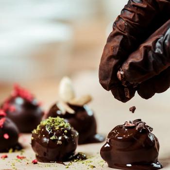 gloved hand decorating chocolates