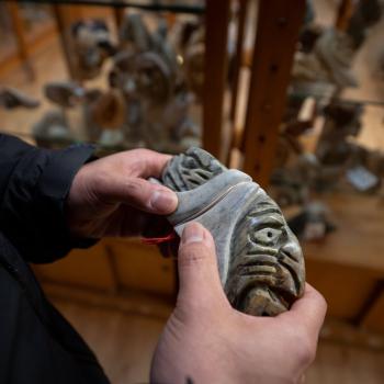 a person holding an indigenous carving