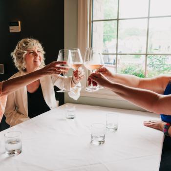 a group of women cheering glasses at a table