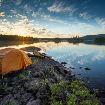 Tent and canoe on shore of lake