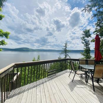Deck with patio chairs looking out over lake