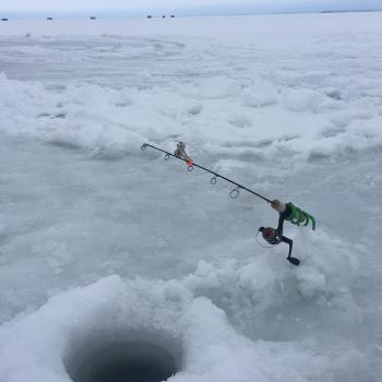 Fishing rod in hole on frozen lake