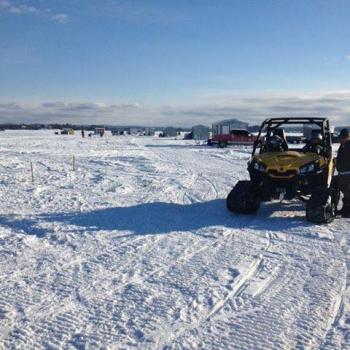 Ice huts on lake with ATV