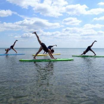 3 people doing stand up paddleboard yoga with Ontario Staycation Adventures