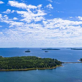 a bunch of islands in the water with the sky and clouds above it