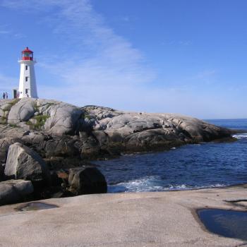 lighthouse on rocks beside a shoreline